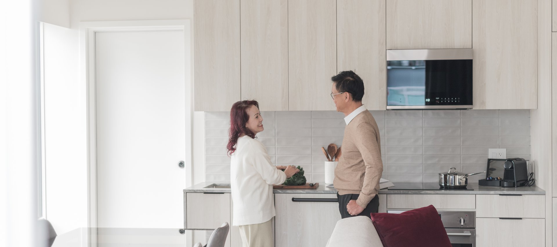 man and women standing in the living room of a waterfront one bedroom suite in Steveston Waterfront Hotel